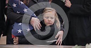 USA veteran funeral, girl and sad family with hug, care and flag for mourning, depression and comfort with mom. Kid