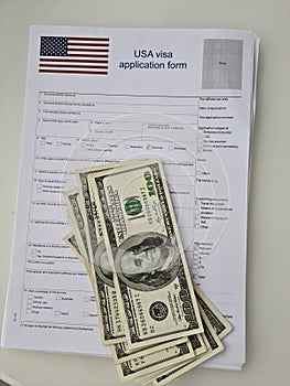 USA visa application paper form lying at passport page and dollars closeup