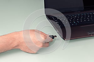 USB - black flash memory in hand by connecting it to the laptop