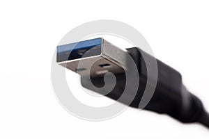 USB cable connector with blurred cable close up on white background