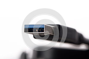 USB cable connector with blurred cable close up on white background