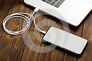 A USB cable connects your phone and laptop