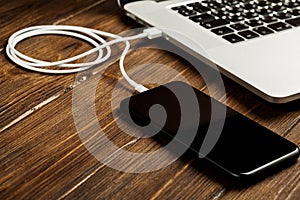 A USB cable connects your phone and laptop