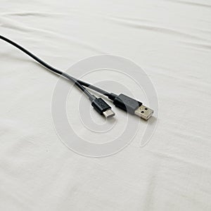 A USB cable featuring two connectors: USB Type-A and Micro USB. The cable is black,