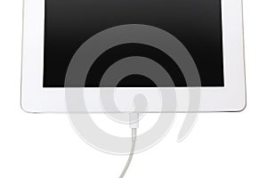USB cable with lightning connector and tablet on white background, top view