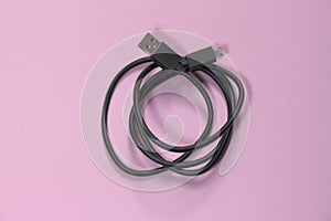 USB cable on pink millennial background.