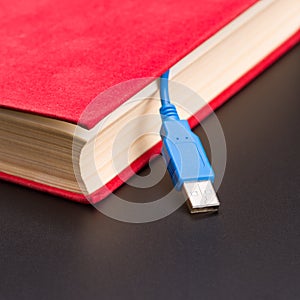 Usb cable sticks out from red book