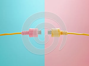 USB cables with colorful connectors joining in the center against a blue and pink background.