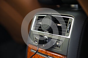 USB charger and magnet A/C mobile phone holder mount in luxury car rear seat.