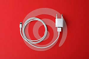 USB charger on red background. Modern technology