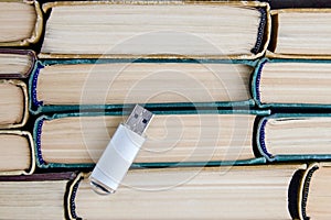 usb flash drive on background of stack of paper books