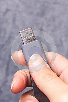 USB flash drive in hand on gray background