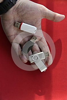 USB flash drive in the palm of your hand on a red background