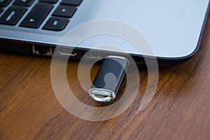 USB memory stick or flash drive attached to the side of a laptop