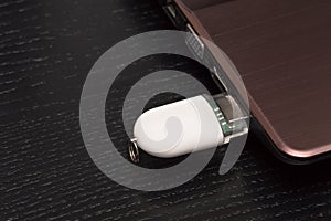 USB memory stick - White flash drive connected to a laptop