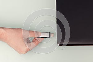 USB metal flash memory on hand with notebook computer connected