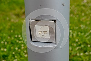 USB socket for charging mobile phones on a pole in the park.