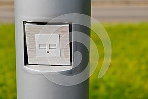 USB socket for charging mobile phones on a pole in the park.