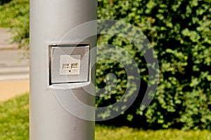 USB socket for charging mobile phones on a pole in the park.