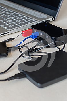 USB splitter device. Seven port USB next laptop on a desk. Charge cell phone battery