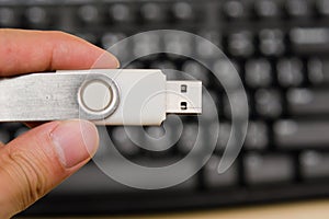 USB thumb drive with hand holding on keyboard background