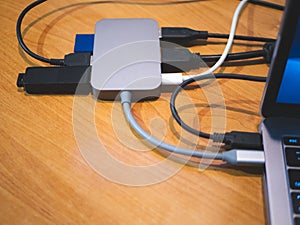 Usb type-c hub connected to laptop with lot of cables connected for peripheral computer device equipment