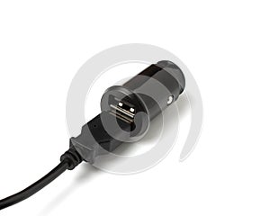 USB wire and black car charger with two USB ports, multifunctional cigarette lighter adapter plug. white background.