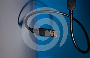 USB wire on blue and gray backgrounds. Close-up