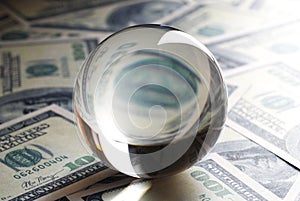 USD dollar banknotes and a crystal ball.