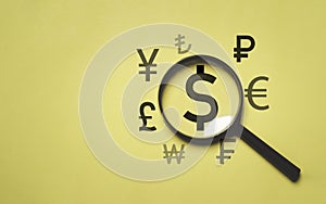 USD dollar sign inside of magnifier glass with the main currency in the world include Yuan Yen Pound sterling Ruble Euro for