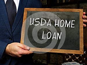 USDA HOME LOAN text in search bar. Businessman looking at cellphone