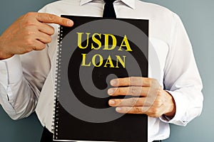 USDA Loan concept. Man holding book.