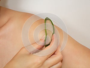 Use of aloe for the skin. The girl smears aloe on skin.