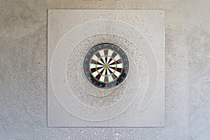Use classic professional sisal dart board on gray wooden background.