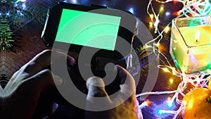 Use hands Game Pad with smartphone on black table with colorful lights, Christmas New Year Composition. Smartphone gaming video