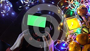Use hands Game Pad with smartphone on black table with colorful lights, Christmas New Year Composition. Smartphone gaming video