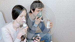 Use nebulizer and inhaler for the treatment. Man and woman inhaling through inhaler mask. Front view.