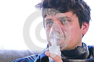 Use nebulizer and inhaler for the treatment. Sick man inhaling through inhaler mask.