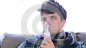 Use nebulizer and inhaler for the treatment. Sick man inhaling through inhaler mask.