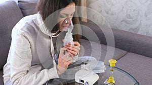 Use nebulizer and inhaler for the treatment. Young woman inhaling through inhaler mask.