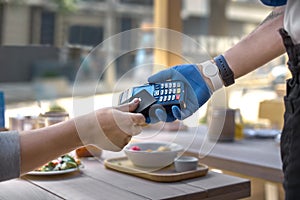 Use payment terminal with contactless credit card with NFC technology for paying in cafe or restaurant, finance concept