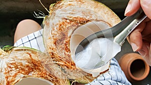 Use spoon picking up young green coconuts with nutrient, health