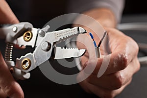 The use of the stripper cutter tool to strip the end of the electrical wire