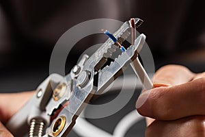 The use of the stripper cutter tool to strip the end of the electrical wire