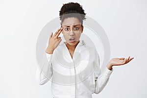 Use your brain, stupid. Annoyed and displeased good-looking african-american entrepreneur in glasses and white shirt photo