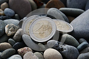 Used 2 euro coins in pebbles Three two euro coins.