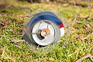 Used aluminum can on grass outdoors. Recycling problem