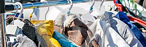 Used baby winter clothes, jackets and coats displayed on rack photo