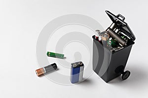 Used batteries in the garbage container on white background. Electronic waste concept. Eco-friendly disposal