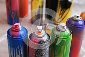 Used cans of spray paints indoors, closeup. Graffiti supplies